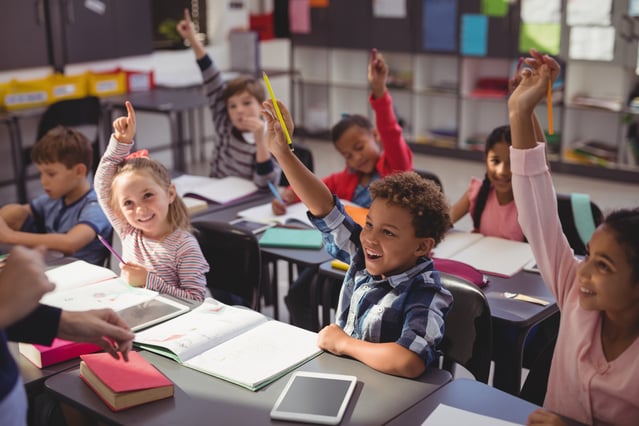 Students raising their hands in class