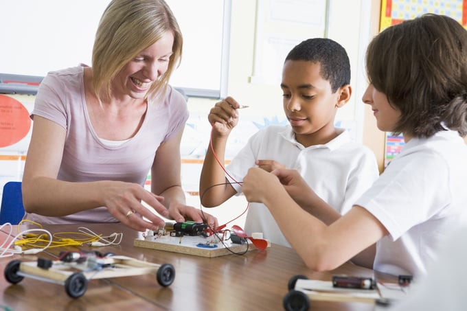 bigstock-Teacher-Helping-Pupils-Learn-P-3915858