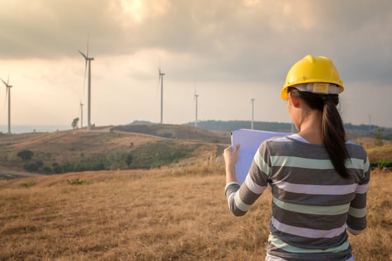 Woman engineer or architect with wind turbines in background