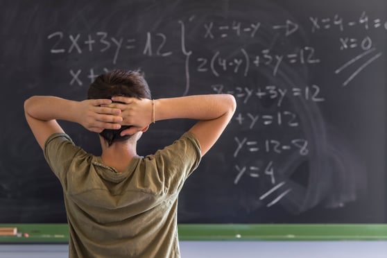 student overwhelmed with math problem on chalkboard