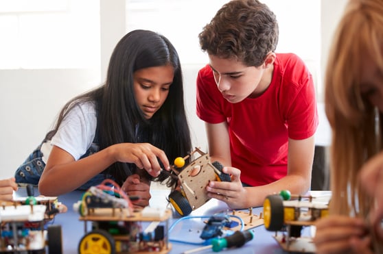 two students building robotic vehicle